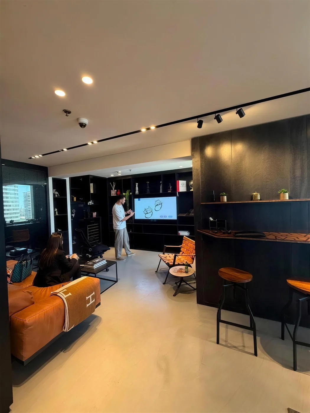 A private appointment at the DAZZ offices at the Israel Diamond Exchange — a client on the leather sofa facing a screen of ring designs